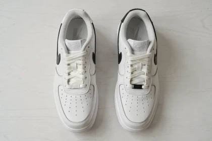 Comparaison entre une vraie Nike Air Force 1 authentique et une contrefaçon posées côte à côte sur une table blanche, vue de dessus