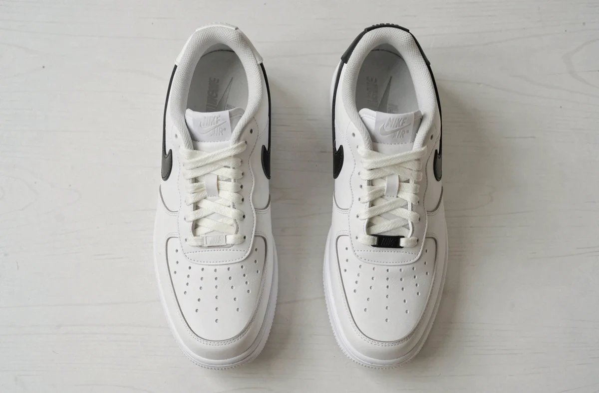Comparaison entre une vraie Nike Air Force 1 authentique et une contrefaçon posées côte à côte sur une table blanche, vue de dessus
